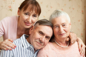 Senior man, woman with their caregiver at home.