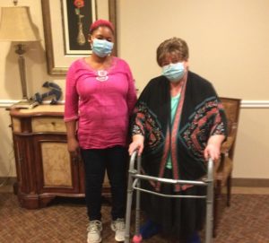 Julie, and older woman in a walker, standing with her aide, Agnes