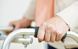 close up of older adult hands holding onto a walker