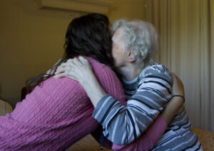 elderly woman hugging younger woman