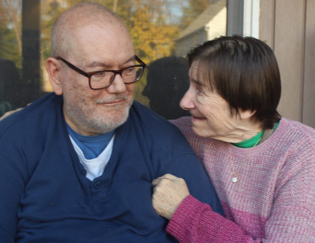 Two people sitting close together and smiling at each other