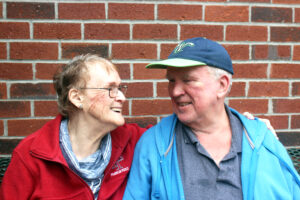 Annette and Michael, two members of the Springwell community, smiling at one another at a supportive housing site.