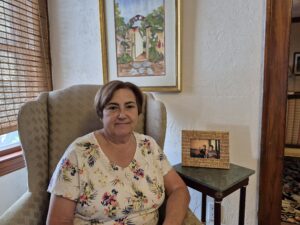 Marilyn, sitting in her living room